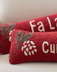 two red pillows with embroidered words on them