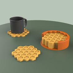 a coffee cup and some honeycombs on a table with a black mug in the middle