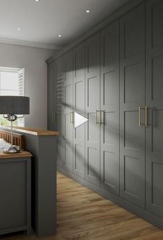 an empty room with gray cabinets and wood flooring