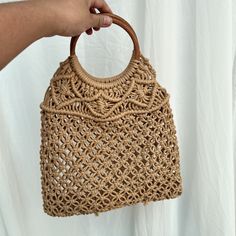 Elevate your style with our handmade crochet tote bag, crafted from durable nylon rope. Measuring 40 cm in length, 1 cm in width, and 33 cm in height, this elegant handbag is perfect for any occasion. Its intricate crochet pattern, paired with a round wooden handle, adds a natural charm to your outfit. Whether for casual outings, beach days, or as a statement piece, this tote bag combines functionality with artisanal beauty. Please note, shipping time is approximately 15 to 21 days. Everyday Macrame Straw Tote Bag, Eco-friendly Macrame Tote Bag, Beige Crochet Bag With Round Handle And Handwoven Details, Beige Crochet Bag With Round Handle, Woven Crochet Top Handle Bag For Daily Use, Everyday Crochet Bag With Round Handle, Beige Macrame Straw Bag For Travel, Beige Crochet Handheld Bag With Braided Handles, Eco-friendly Beige Crochet Bag With Top Handle