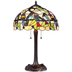 a lamp that is sitting on top of a wooden stand with a bird design on it