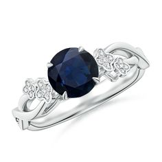 an oval blue sapphire and diamond ring with two diamonds on the shoulders, set in white gold