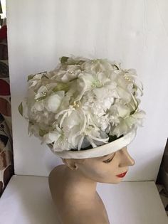 "Vintage 1960's hat. White floral with Green leaves bucket style hat. The label is *SEARS Fashion Millinery*. Sears Roebuck and Co. USA. *MORE INFORMATION BELOW* CONDITION: No issues noted. MEASURES: Inside circumference~21 1/2\" Height~5\" Front to back~8\" Left to right~7\" *WE APOLOGIZE~BUT WE NO LONGER SHIP TO GERMANY, ITALY OR SPAIN. IF ORDERS COME IN FROM GERMANY, ITALY OR SPAIN, WE WILL HAVE TO CANCEL THEM AND REFUND YOUR MONEY. SORRY FOR THIS INCONVENIENCE*" White Vintage Cloche Fascinator, Vintage White Cloche Fascinator, Vintage Cream Mini Hats With Curved Brim, Vintage White Cloche Hat, Vintage Cream Mini Hat With Curved Brim, Vintage White Fascinator Hat, Vintage Cream Costume Hat With Curved Brim, White Vintage Fascinator Hat, Vintage White Fascinator With Curved Brim