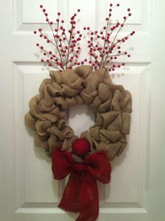 a burlock wreath with red berries hangs on the front door