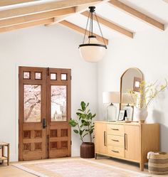 a living room with wooden furniture and a large rug in front of the door that leads to another room