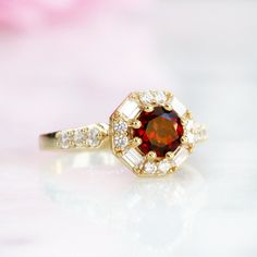 Beautiful Hexagon Garnet Ring ►Base Metal: Sterling Silver (S925) ►Plating: 14K Gold Vermeil ►Accented with Simulated Diamonds (CZ) ►Average band width: 2.3 mm. ►Halo size: 10.5mm (approx.) Center Stone: Garnet Shape: Round Measurements: 6.0 mm Carat Weight: 0.85 ct. (approx.) Cut: Brilliant Gemstone creation: 100% Natural Hardness: 7.5 (Mohs scale) ►Please be aware that plated jewelry can wear off over time, if this is a concern we would suggest going with a sterling silver or solid gold ring o Classic Red Cluster Ring, Round Garnet Cluster Ring For Anniversary, Classic 14k Gold Birthstone Ring For Proposal, Elegant Garnet Cluster Ring For Anniversary, Classic 14k Gold Ruby Ring With Halo Design, Classic Red Birthstone Ring With Center Stone, Classic Garnet Diamond Ring With Center Stone, Classic Red Gemstone Halo Ring, Classic Red Halo Ring With Gemstone