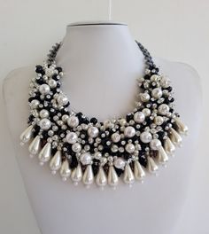 Each piece of our statement necklaces is handmade and one of a kind made in Italy. Our creations is made of high quality materials such as crystals and rhinestones. Each embroidered material is carefully hand sewn. Very glamorous and stylish. Perfect gift to someone you like. Materials Strass stones in Crystal color, and White and Black pearls in different dimension. Jeweled drop fringe in White pearl color.  Black satin fabric backing. Aluminium chain with lobster closure. Measurements Weight approximate 250 grams. Chain lenght 24 cm - 9,448 in Circumference approximate 59 cm - 23,22 in Feel free to contact us if you have any question. Thank you so much for looking at our shop and our articles each of them, single piece. Crystal Beaded Necklaces With Jewels For Party, Crystal Beaded Necklace With Jewels For Party, Handmade Choker Bridal Necklace For Party, Handmade Bridal Choker Necklace, Handmade Bridal Choker Necklace For Party, Handmade Bridal Choker For Party, Handmade Pearl Necklaces For Party, Handmade Elegant Crystal Rhinestone Necklace, Unique Pearl Necklaces For Party