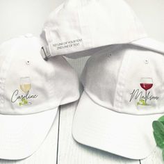 two white caps with wine glasses embroidered on them