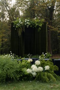 an outdoor stage with flowers and greenery in the foreground