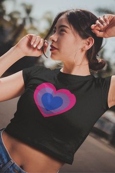 a woman wearing a black shirt with a pink heart on the front and blue heart on the back