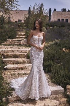 a woman in a wedding dress standing on some steps