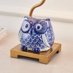 an owl figurine sitting on top of a wooden stand