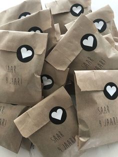 small brown bags with black and white heart stickers on them sitting on a table