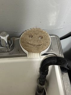 a dirty sink with a smiley face on it