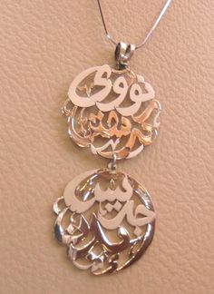 all family names arabic calligraphy sterling silver 925 pendant with chain matt and polishing father and mother upper circle sons in lowernames in the sample is Noah and  christen , Grace and Eden please allow 10 to 15 days to complete , this is made to order item .write your name or the names you want in english or arabic , with the order please .we use 12 mm minimum thickness silver plate so it will be strong and heavy .Any change on design can be discussed and applied .the name circle diamete Traditional Silver Engraved Name Necklace, Traditional Engraved Silver Name Necklace, Names Arabic, Family Names, Pendant With Chain, Name Jewelry, Rings Cool, Snake Chain, Custom Rings