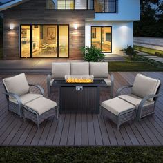 a fire pit sitting on top of a wooden deck next to two chairs and a table