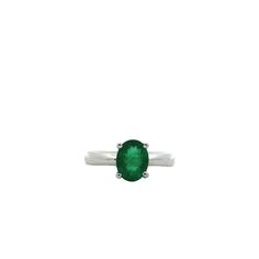 an oval shaped green stone sits on top of a silver band, with a white background