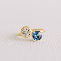 Meet our By Brockton signature bezel set two stone engagement ring in 18k yellow gold.  This custom made ring is set with a repurposed 0.73 carat old European cut diamond and a 0.77 carat cushion cut blue sapphire.  This one-of-a-kind ring is in stock and ready to ship.  Made in a small Toronto workshop (not a factory). This ring can also be custom ordered with your choice of gems.  Please contact us for details.   GEMS O.73 carat antique repurposed old European cut diamond, SI1 clarity, K colour. 0.77 carat cushion cut sapphire from Madagascar.   SIZE This ring is a US ring size 6.5.  Complimentary sizing comes with the ring. Please let us know you size when ordering.  Band is approximately 2 mm round. MATERIALS Natural diamond and sapphire in 18k yellow gold. SHOP POLICIES  Please see sh Two Stone Engagement Ring, Ring Aesthetic, Christmas Ring, Bezel Engagement Ring, Mom Ring, Round Engagement Rings, Cushion Ring, Jewellery Inspiration, Bezel Ring