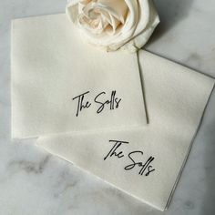 two white napkins with the words the sells and the sale written on them next to a flower