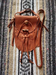 This Deer Skin Neck Bag is larger than the other neck bags, and will still be very comfortable wearing it. The total width is 4 1/2"with a usable width of 4.0" and is 4 1/2" deep. The fringe is approx 2 1/2" long. The strap measures approx 34 1/2" long, not counting the fringed ends. The button is cut from Deer antler. I still use the tried & true method of closure, that being wood peg and lace ( thong ), with wooden beads. Color: Medium Brown Leather Pouches, Deer Antler, Deer Skin, Lace Thong, Leather Pouch