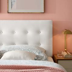 a bedroom with pink walls and white headboard, two nightstands on either side