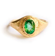 The Emerald Signet engagement ring is a truly special ring, hand formed and heavily hammered gold glittering like treasure around the bright green stone, at once opulent and organic with an ancient feel. The substantial .75 carat emerald measures 6x4mm, and is set low in a hand-formed 14k recycled yellow gold bezel. The signet profile tapers from 9mm on the topside of the ring to a slim 2mm on the underside, perfect for everyday wear. Emerald Signet | Emerald Signet Engagement Ring Hammered 14k Unique Yellow Gold Oval Emerald Ring, Unique Oval Emerald Ring In Yellow Gold, Unique Oval Emerald Ring In 14k Gold, Oval Emerald Ring In 14k Gold, Timeless Green Round Band Jewelry, Oval Green Signet Ring For Wedding, Fine Jewelry Green Signet Ring With Birthstone, Green Oval Signet Ring For Wedding, Unique Yellow Gold Emerald Promise Ring