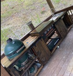 an outdoor bbq grill on the back deck of a house with wood flooring