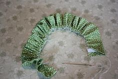 a green and white polka doted headband on the floor next to a pair of scissors