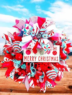 a christmas wreath with red, white and blue decorations on it that says merry christmas