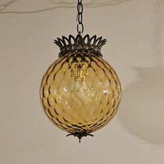 a chandelier hanging from a chain in a room with white walls and ceiling