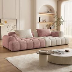 a modern living room with pink and white couches, coffee table and rugs