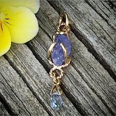 "Please go to my Instagram to watch the video about this pendant ~ A lovely genuine purple-blue color tanzanite glistens in a hollow 14k yellow gold wire bezel. Set with a light blue color sapphire bead is so fiery, vibrant and intense! A unique little piece with so much character. All handcrafted by me in my Michigan studio. Gem: approx. 12mm x 7mm / 2.15ct / genuine purple-blue tanzanite / with inclusions and imperfection surface 6mm x 3mm/ genuine light blue bead / with inclusions and imperfe Lavender Tanzanite Jewelry For Gifts, Handmade Tanzanite Yellow Gold Jewelry, Unique Tanzanite Jewelry Gift, Unique Tanzanite Jewelry For Gifts, Necklace Sapphire, Boulder Opal Ring, Halo Necklace, 14k Yellow Gold Necklace, Yellow Gold Necklace