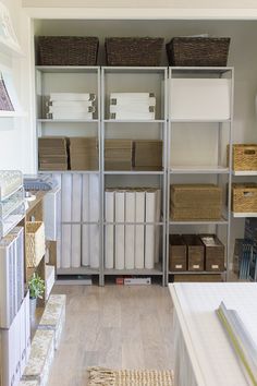 an organized room with shelves, baskets and other items