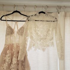 two dresses hanging on a rack in front of a window