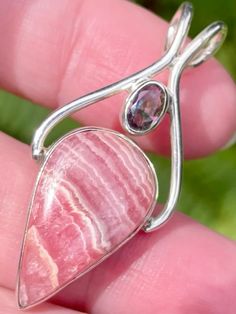 Only $34.99! Look at this gorgeous a Rhodochrosite and Mystic Topaz Pendant! Rhodochrosite is all about love. Love of oneself, love of others, spiritual love, love of Mother Earth and universal love are all at the heart of this stone. It helps to heal old wounds so that you can love yourself again and feel worthy of the love of others. This is also a perfect stone for finding new love, renewing old love and making a new loved one feel confident in his or her place in the relationship. While Mystic Topaz or Fire Topaz is the name of White Topaz treated by titanium to Imbue the stone with a rainbow of colors. Topaz is said to promote the successful completion of endeavors. It also improves relationships through better quality of communication and understanding. This stone also promotes cle Natural Tourmaline Gemstones As Gifts, Natural Tourmaline Gemstones For Gifts, Pink Gemstones For Gifts, Unique Pink Gemstones For Gifts, Pink Tourmaline Jewelry For Healing, Pink Natural Stones Gemstones In Sterling Silver, Unique Tourmaline Gemstones For Gifts, Healing Pink Tourmaline Jewelry, Finding New Love