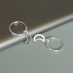 A PAIR of sterling silver hoops. Comes with a detachable cut out crescent moon charm. The charm is multipurpose and can be used with a neck or bracelet chain too. Dimension: Hoop- 15 x 1.5 mm Charm: 6 x 12 mm Drop length- 23 mm These earrings are made of 925 hypoallergenic sterling silver and plastic. Please note this price is for ONE PAIR. All my pieces are sent in a gift box. I can include a personal message from you if needed You are welcome to contact me at... bhavnakwintra1956@gmail.com For Adjustable Moon Charm Hoop Earrings, Adjustable Hoop Earrings With Moon Charm, Nickel Free Moon Shaped Hoop Earrings Gift, Huggie Hoop Earrings With Moon Charm For Gift, Celestial Small Hoop Sterling Silver Jewelry, Silver Hoop Earrings With Moon Charm, Sterling Silver Moon Earrings For Everyday, Celestial Sterling Silver Small Hoop Jewelry, Moon Shaped Sterling Silver Earrings For Everyday