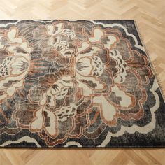 a large rug with an intricate design on top of wood flooring in a room