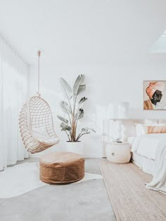 a bedroom with white walls and flooring has a hammock hanging from the ceiling