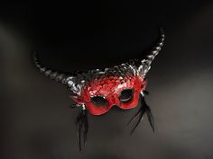 Step into a world of fantasy in a dark mythical beauty inspired long horn masquerade mask. This red/black mask is designed to make you the center of attention at any masquerade ball or Halloween party! Age Group/Gender - Adult/Women Size/Type - One size fits all adults Mask Color - Red/Black Mask Material - Polyresin Accent Material - Paint Special Features - Feathers Fantasy Horned Costume Accessories For Masquerade, Fantasy Horned Masquerade Mask For Costume, Fantasy Masks For Carnival Events, Gothic Masquerade Mask For Carnival Festival, Gothic Eye Mask For Fantasy Events, Fantasy Halloween Masks, Horned Masquerade Mask For Halloween Cosplay, Gothic Horned Masquerade Mask For Costume Party, Fantasy Horned Masks And Prosthetics For Party