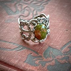 Victorian style sterling plate silver ox filigree ring measuring 18mm wide at the widest point and fully adjustable.In the center is a 10x8mm oval unakite cabochon.  Unakite is  terracotta and moss colors blended together.  The stone you receive may vary slightly from the one pictured. Neutral Tones Fashion, Indie Jewelry, Rustic Jewelry, Vintage Style Jewellery, Funky Jewelry, Filigree Ring, Brass Ring, Silver Filigree, Victorian Style