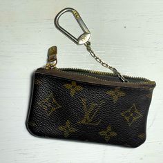 a black and brown purse with a key chain hanging from it's front pocket