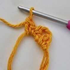 the crochet hook is being used to make an ornament with yarn