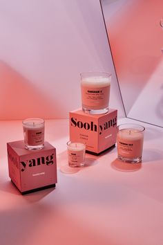 three candles sitting next to each other in front of a pink box with the words sooh gang on it