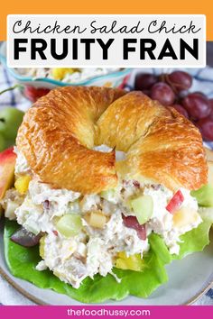 chicken salad sandwich on a croissant with grapes and apples