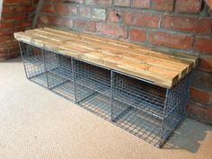 a wooden bench sitting next to a brick wall on top of a carpeted floor