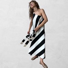 Black and white wide-striped A-line maxi dress with one shoulder strap and a detached tie, that can be used as a scarf, tied into a bow on the strap, or a hair band.   Fabric: 100% drill cotton. Size is fluid as the dress comes out in a fluid drape, with an elasticated strap.  Size XS/S and M/L available Length: 112 cm | 44 in Seen on a size XS, 5. 5 ft, 1. 66 m, C cup, for reference.  Made in our London atelier.  ___Dry clean only 100% Cotton drill.  Dry clean only. One Shoulder A Line Dress, Dress With One Shoulder, A Line Maxi Dress, August Birthstone Jewelry, July Birthstone Jewelry, C Cup, Wide Stripes, Gifts For New Mums, Pearl Jewellery Earrings