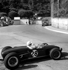 an old photo of a man driving a race car