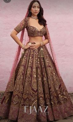 a woman in a brown and gold bridal gown standing with her hands on her hips