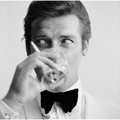 English actor Roger Moore, downs a Martini as James Bond, 17th July 1968. (Photo by Peter Ruck/BIPs/Getty Images)  As an authorized Getty Images Gallery partner, we offer premium quality prints scanned from the original negatives and plates from Getty’s darkroom. All photographic prints are accompanied by a Certificate of Authenticity from Getty Images Gallery.  The B & W resin printing process is a method which is part hand printed and part machine processed on archival paper. An embossed G Roger Moore 007, Shaken Not Stirred, Rudolf Nureyev, Slim Aarons, Roger Moore, Photographie Inspo, Lauren Bacall, Humphrey Bogart, Bond Films