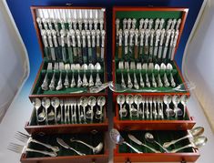 an assortment of silverware is displayed in wooden boxes with matching utensils and spoons